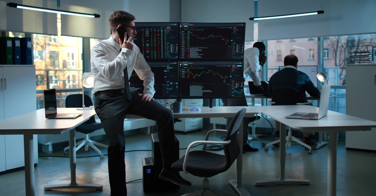 businessman talk on smartphone while sitting at desk 