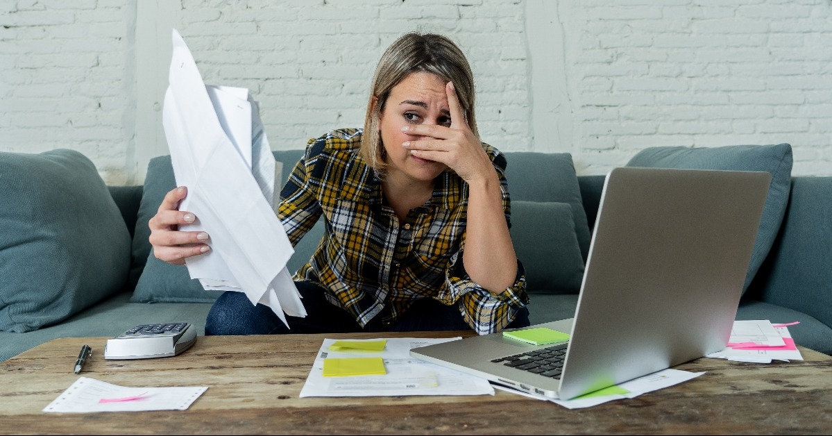 overwhelmed young woman paying bills 