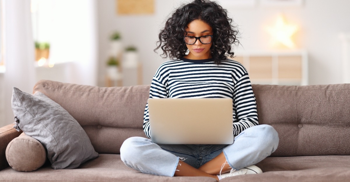 woman using laptop on sofa