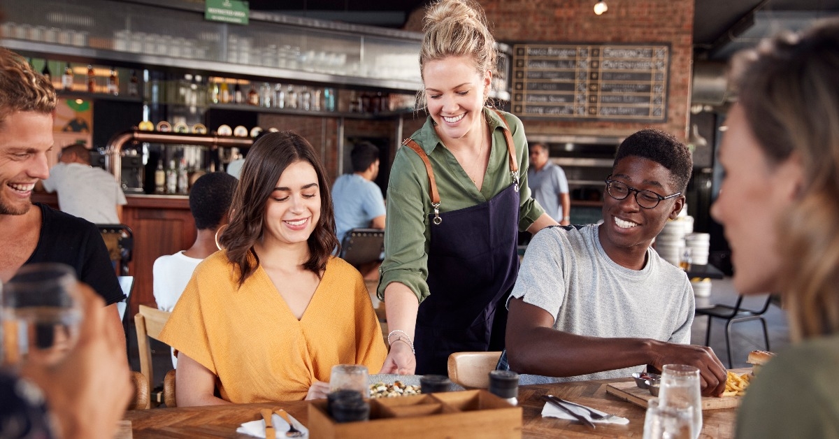 waitress serving group of young friends