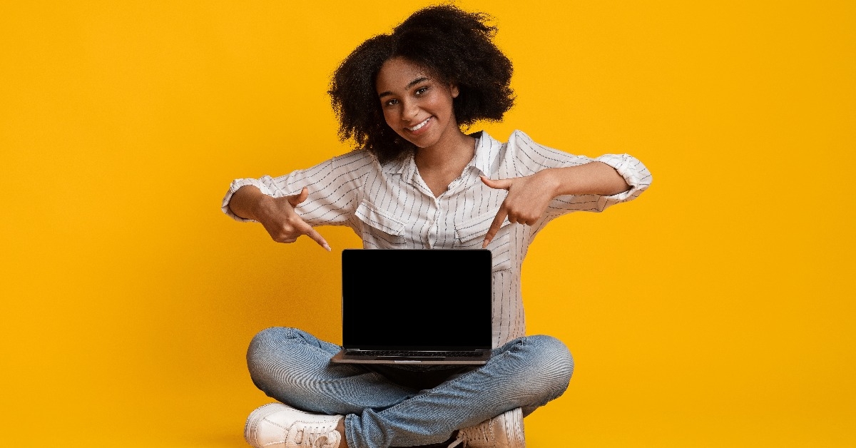 Afro woman pointing at laptop