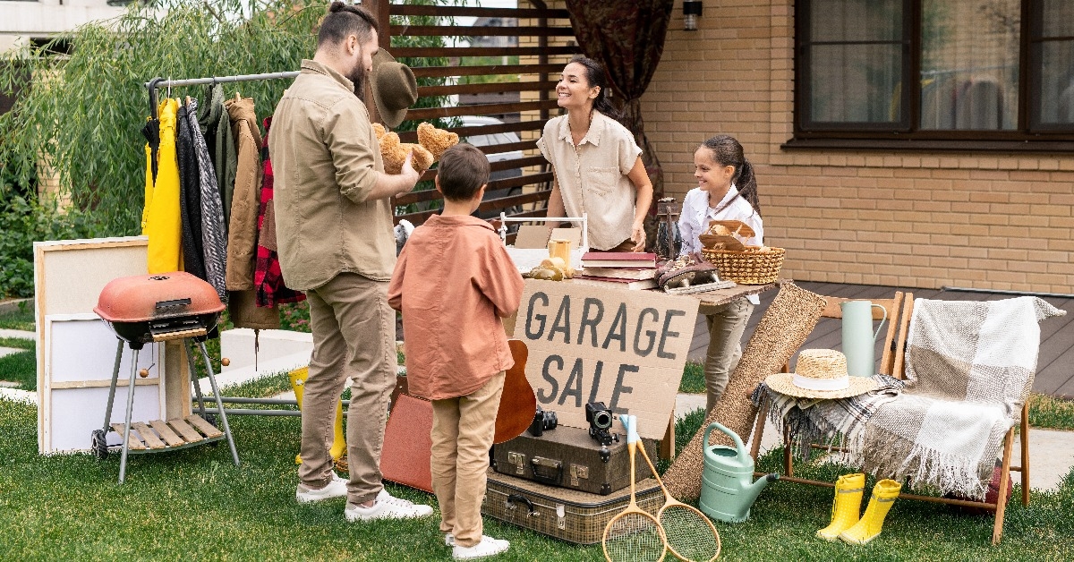 bearded man standing at table with various goods 