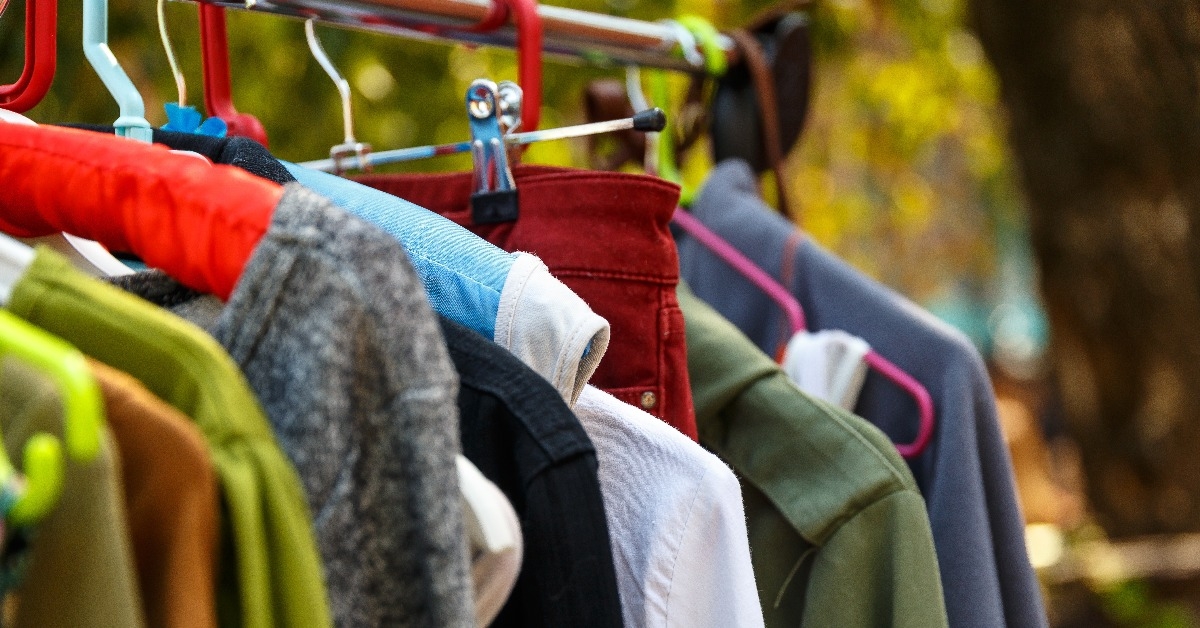 hangers with men's and women's clothing at the garage sale