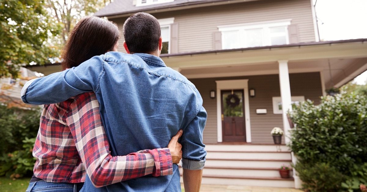 rear view of loving couple looking at house