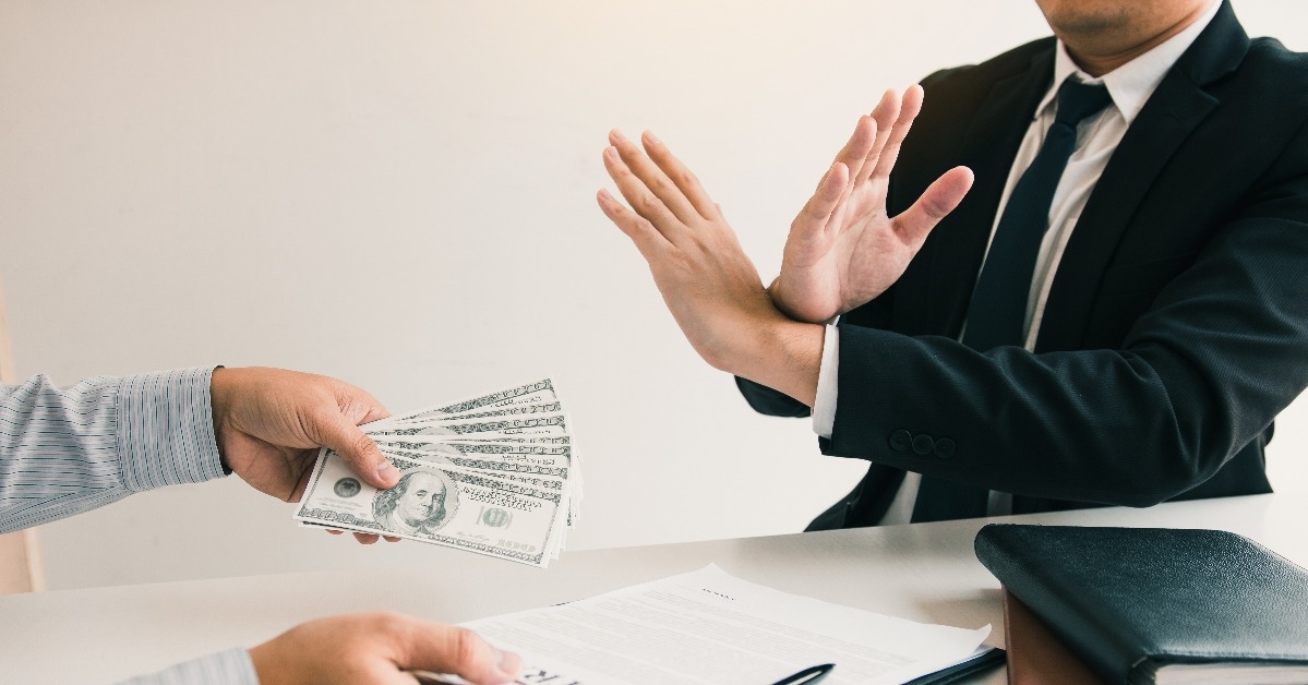 businessperson refusing bribe given money by partner