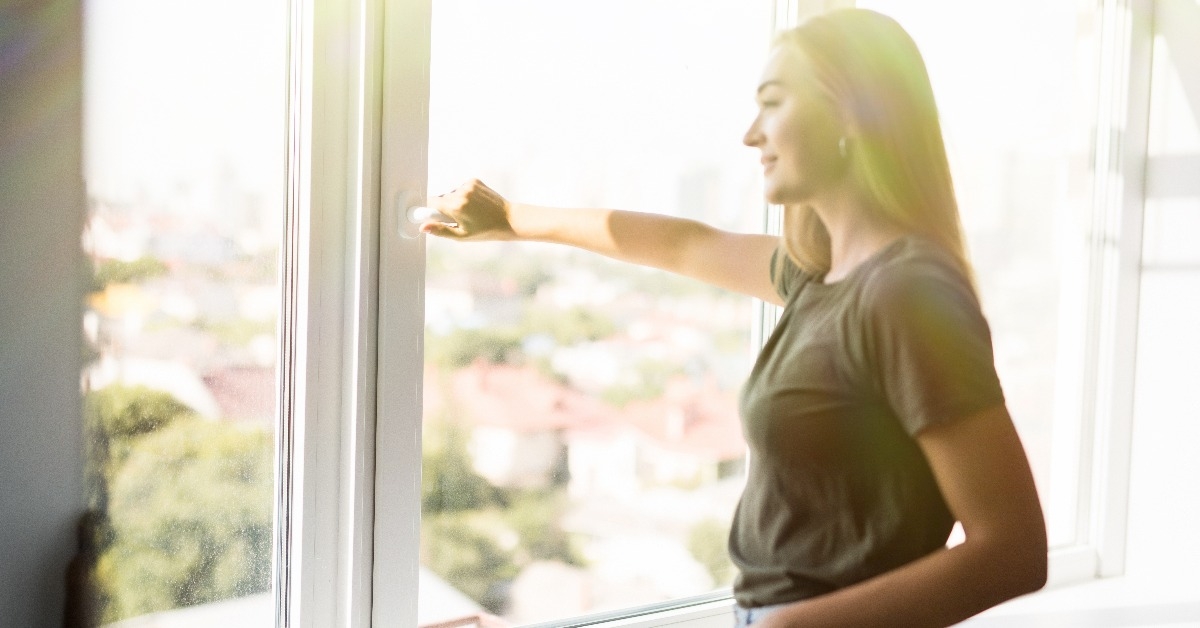 woman open plastic windows for fresh air indoor