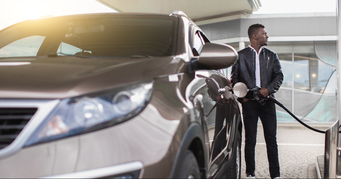  bearded guy in stylish casual outfit refueling his luxury car