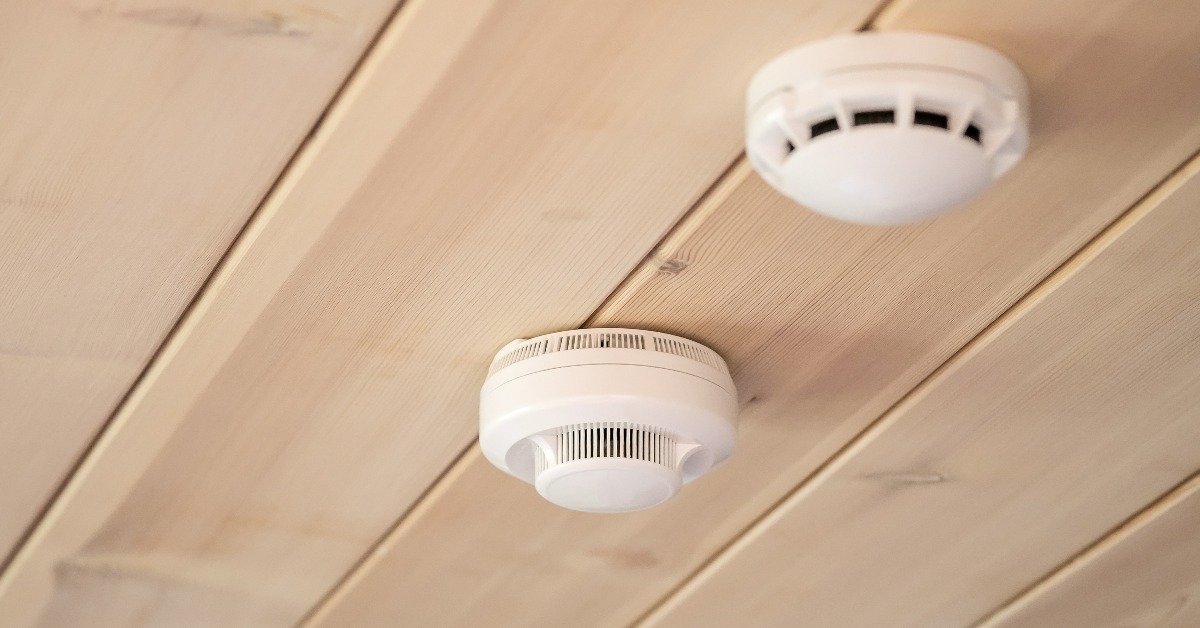 smoke and carbon monoxide detectors in a wooden ceiling