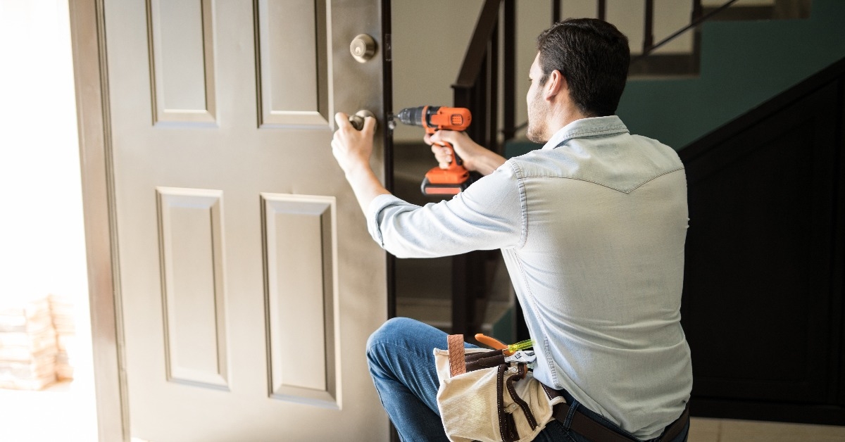 young man fixing a door lock