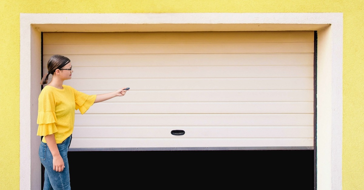  young woman use remote controller for closing garage door
