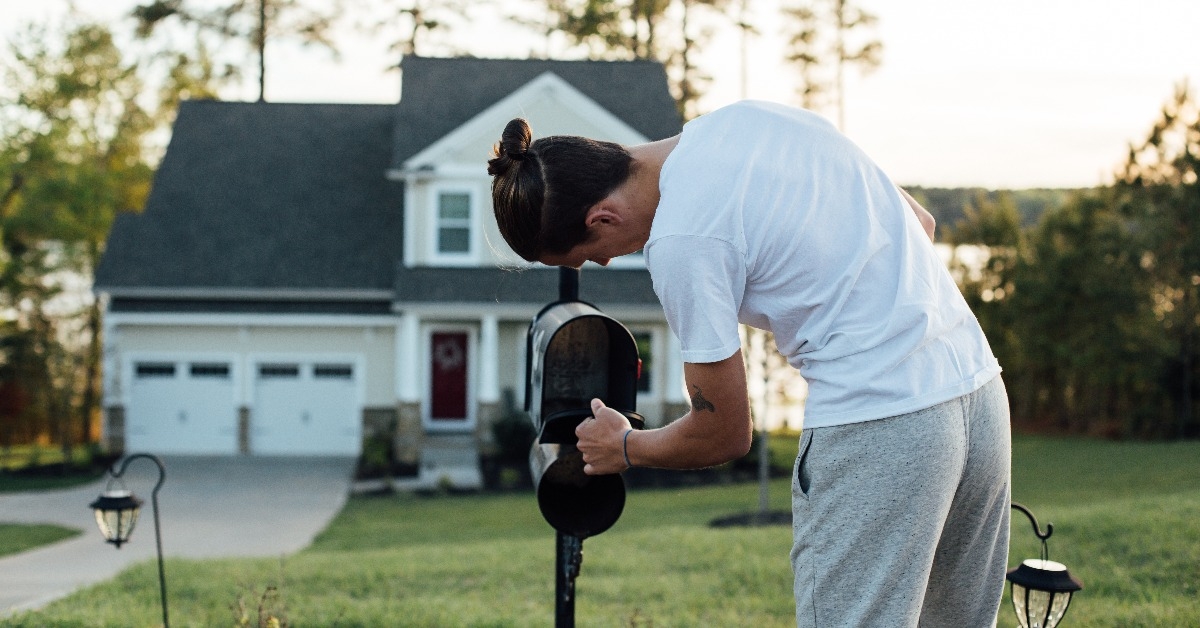 home owner checks on new letters and bills in his american typical mailbox