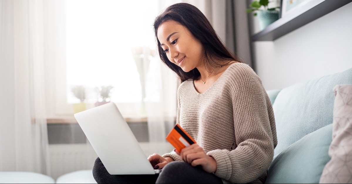 asian woman making online payment using laptop for shopping at home