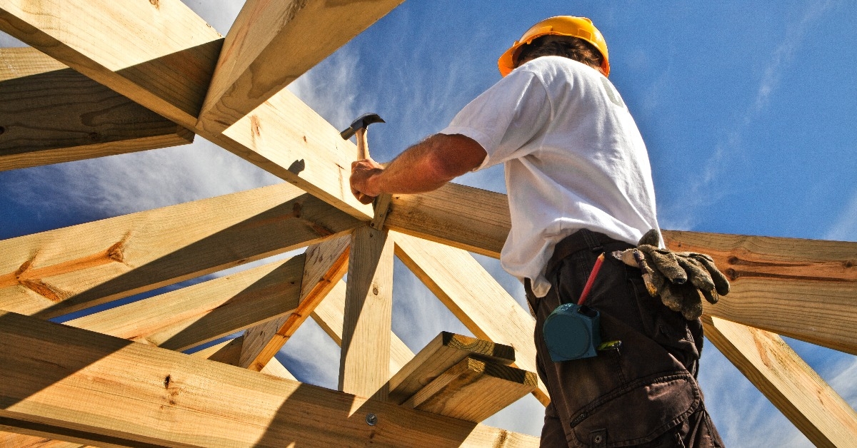 carpenter working on roof structure at construction site