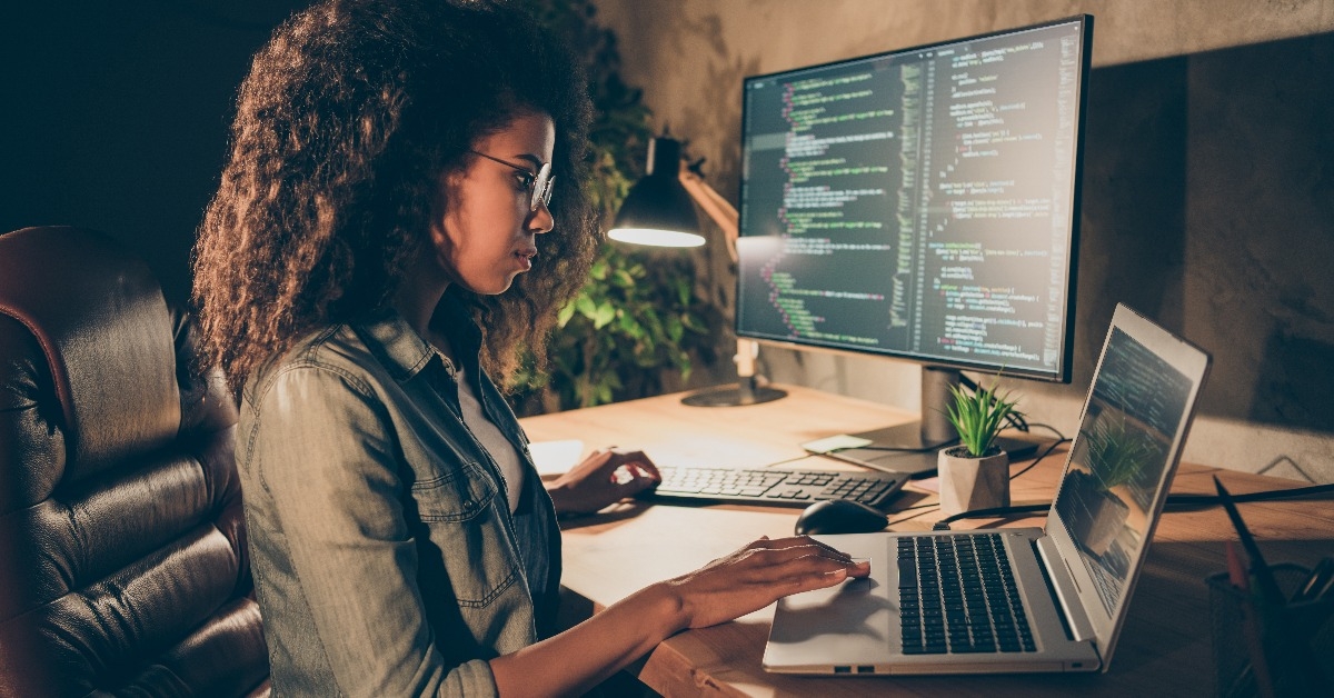 female web designer writing binary java script code in workstation