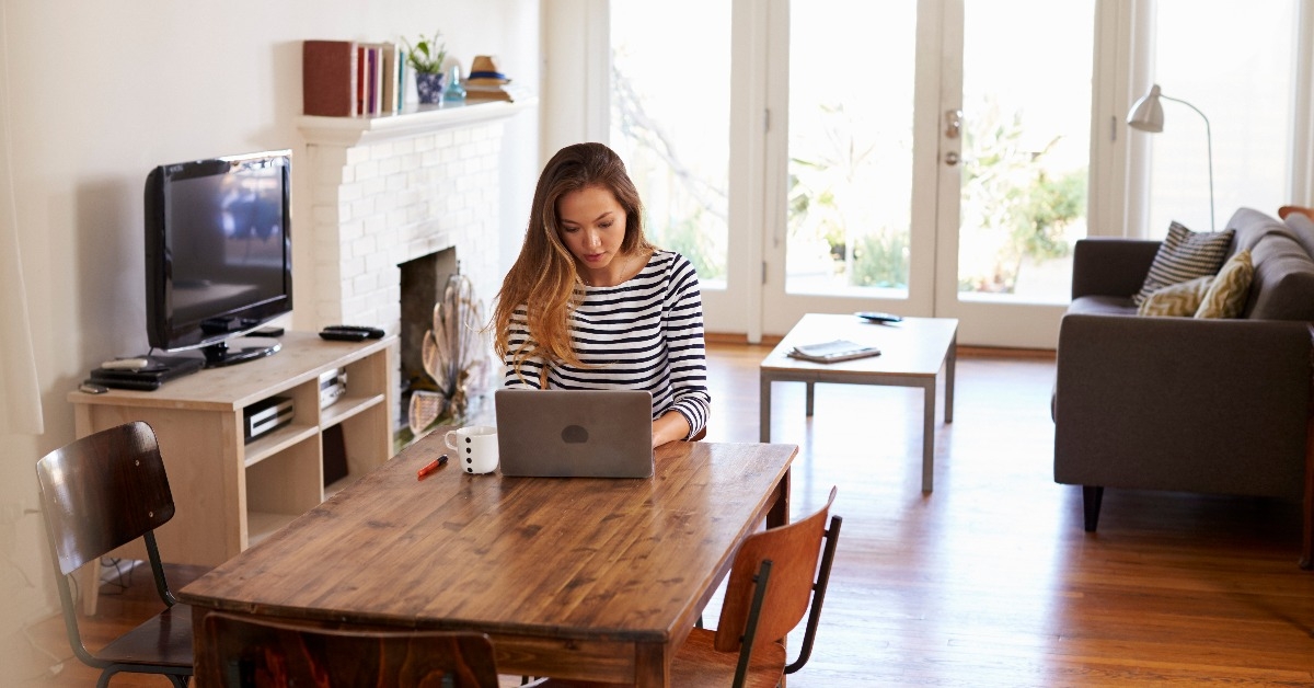 woman working from home using laptop on dining table