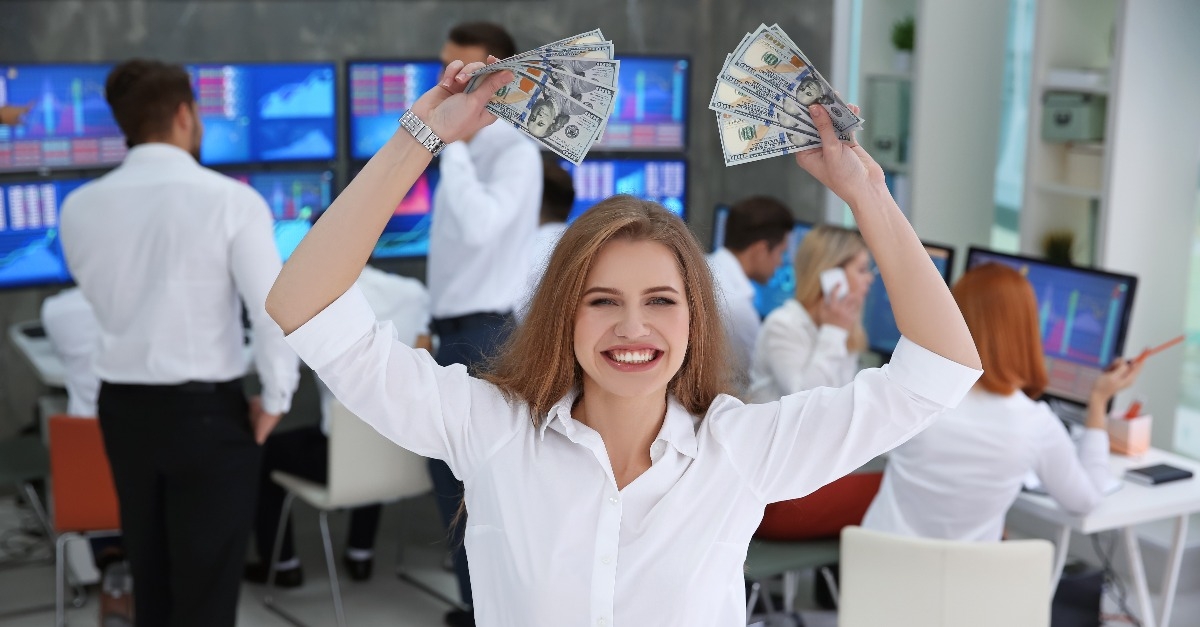 female stock trader with dollar bills in office