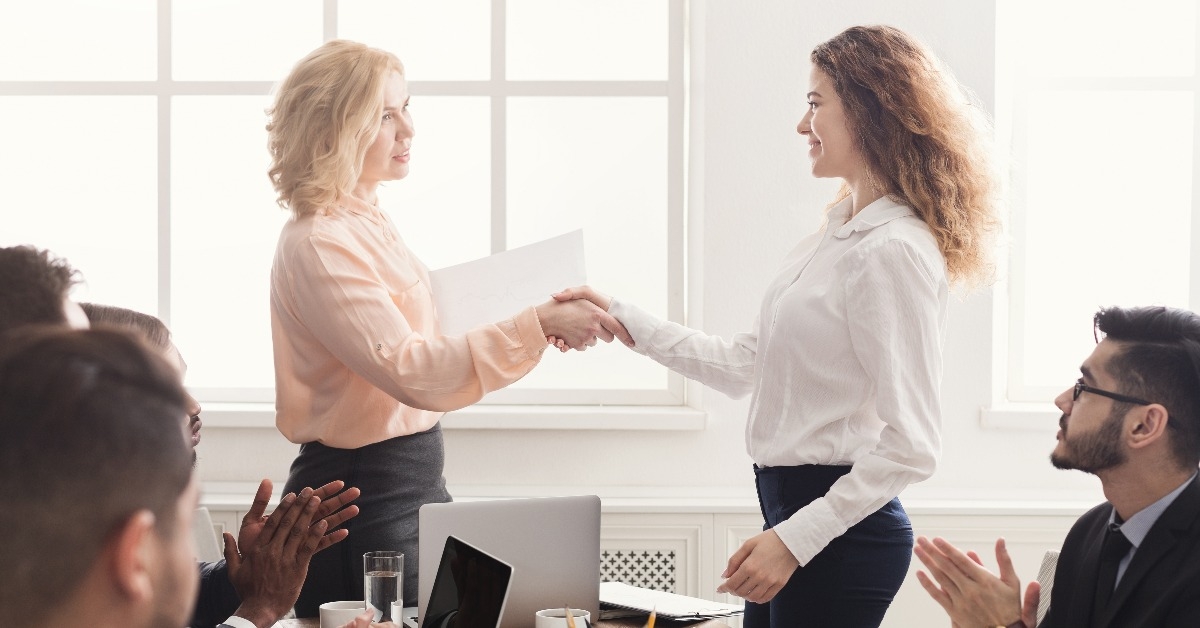 boss handshaking employee congratulating with promotion