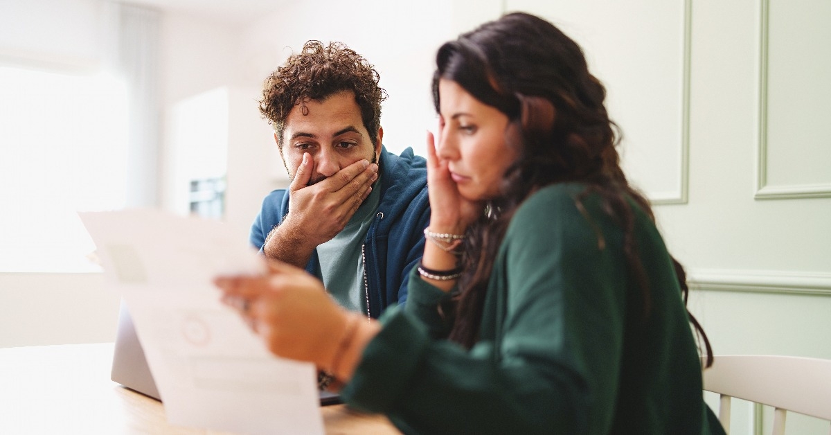 young married couple is worried looking at the electricity bill 