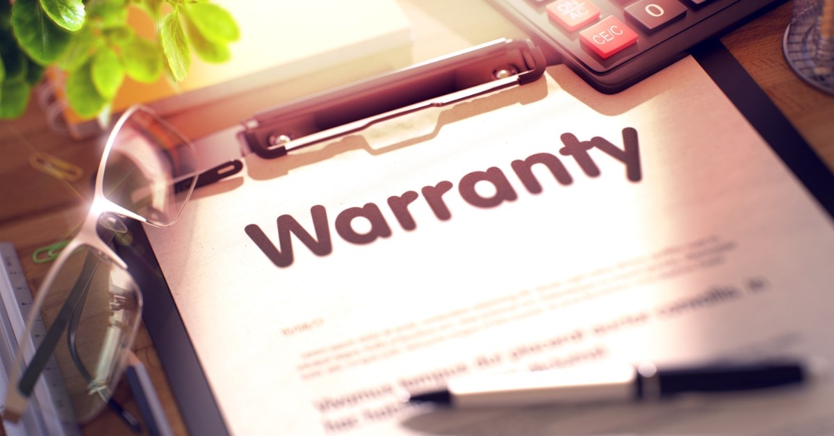 warranty papers on a clipboard with pen and calculator