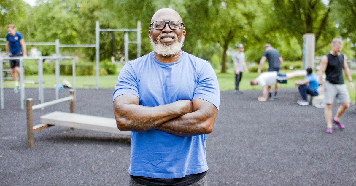 muscular black senior man with his arms folded smiling to camera