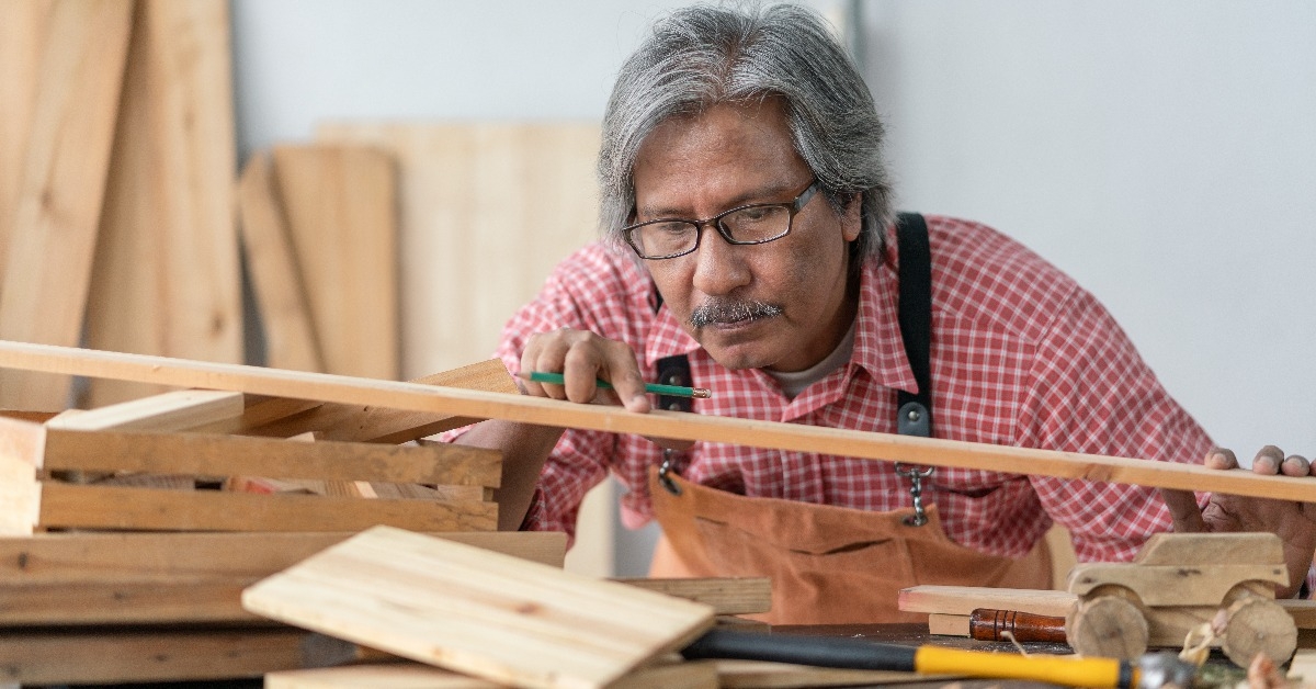 senior carpenter man looking wood plank at carpenter workshop