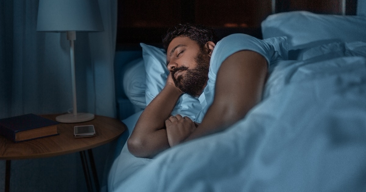 man sleeping in bed at home at night