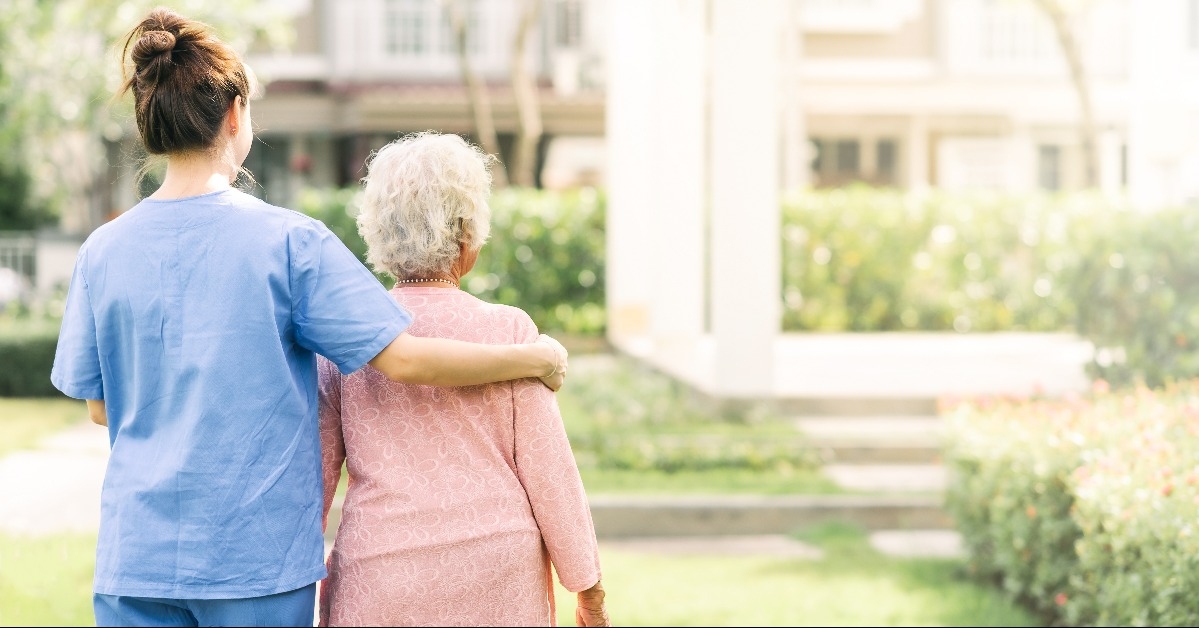 caregiver support walking with elderly woman