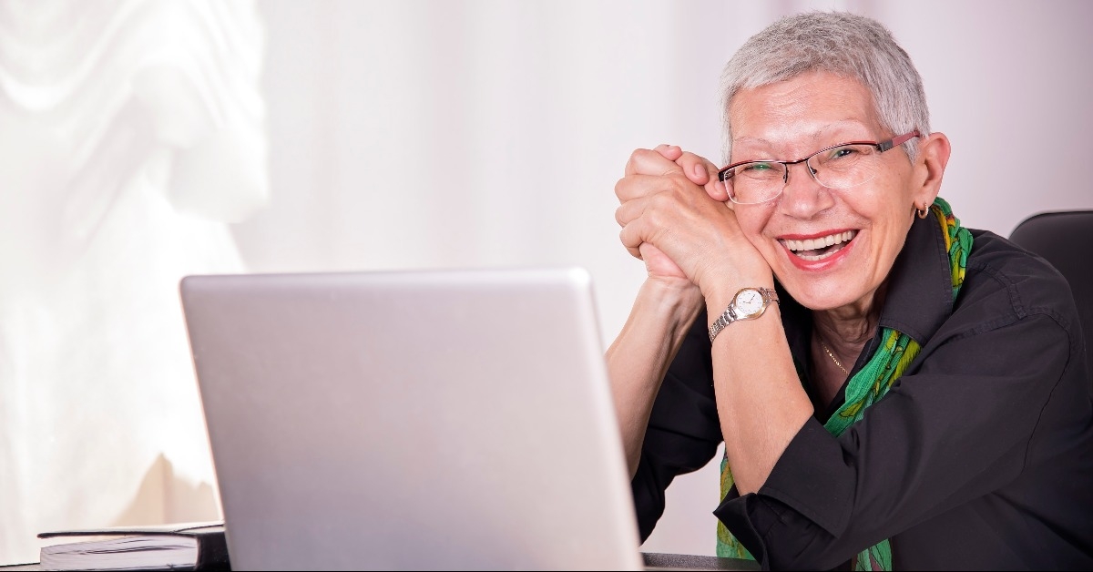  happy senior businesswoman working on her laptop