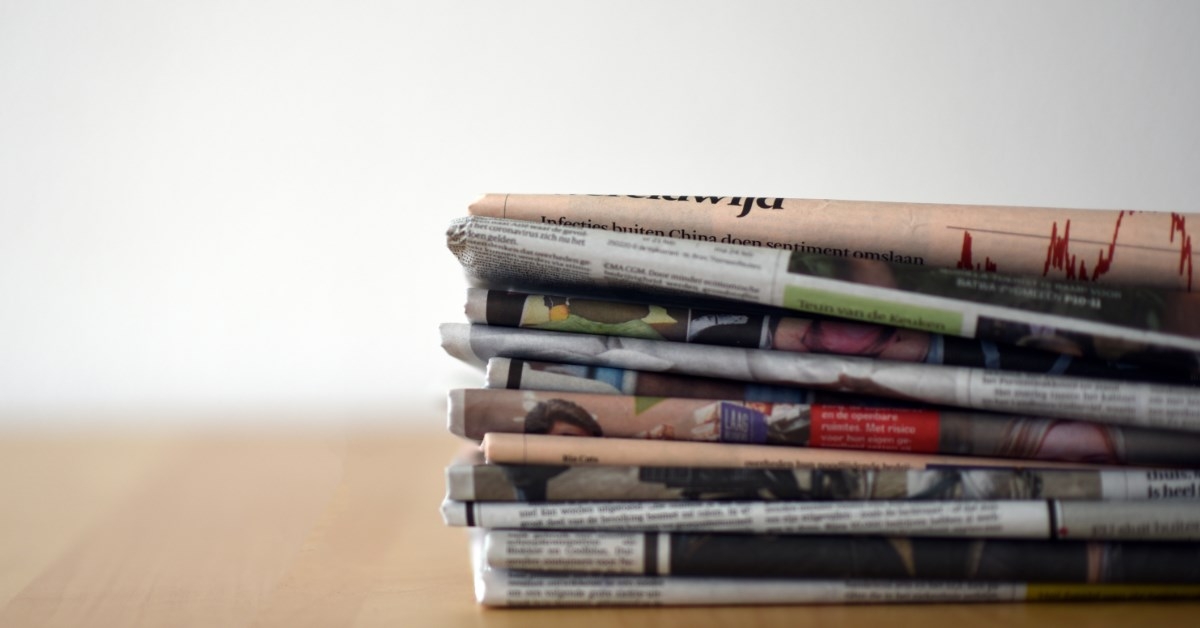 a pile of newspapers stacked on a table
