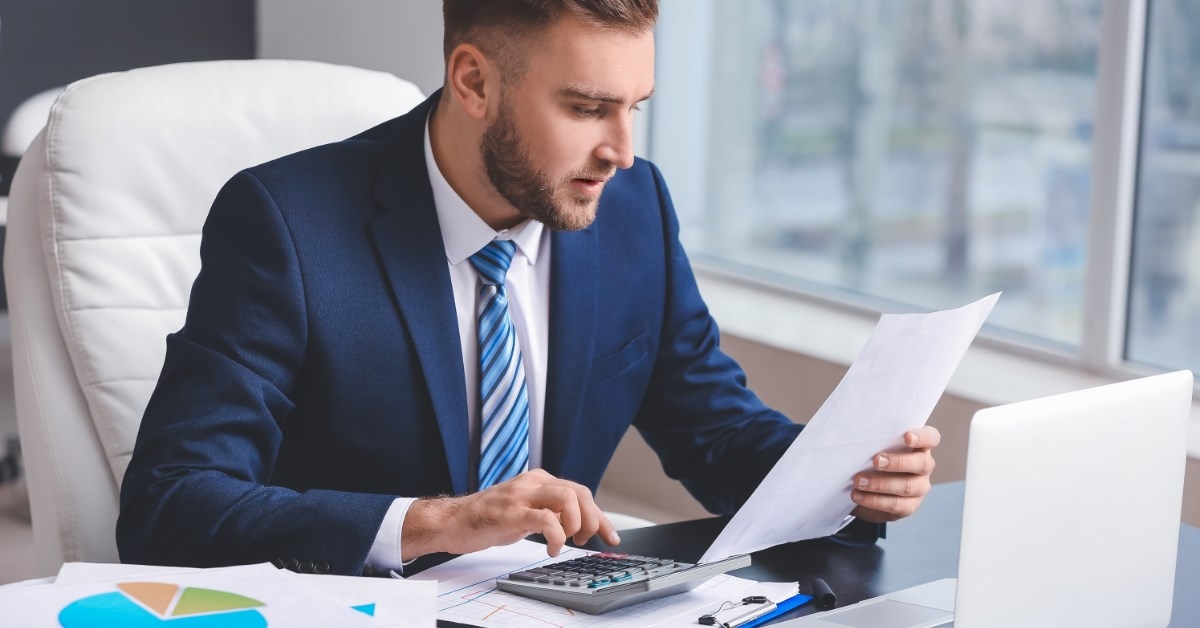 a young businessman using calculator in office