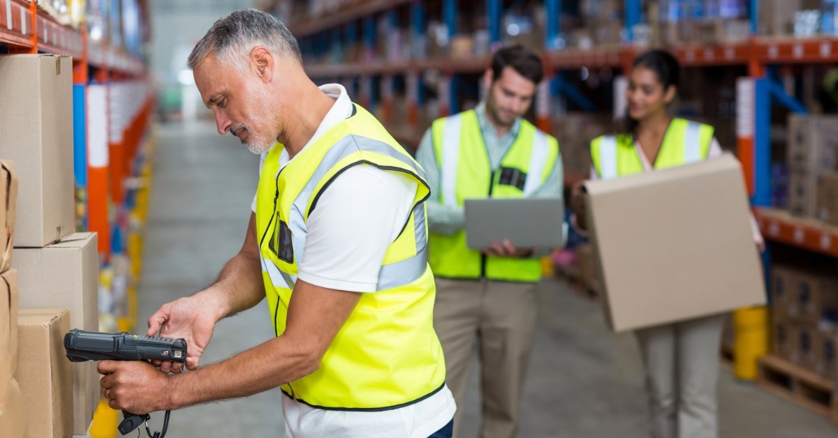 worker scanning boxes in a warehouse