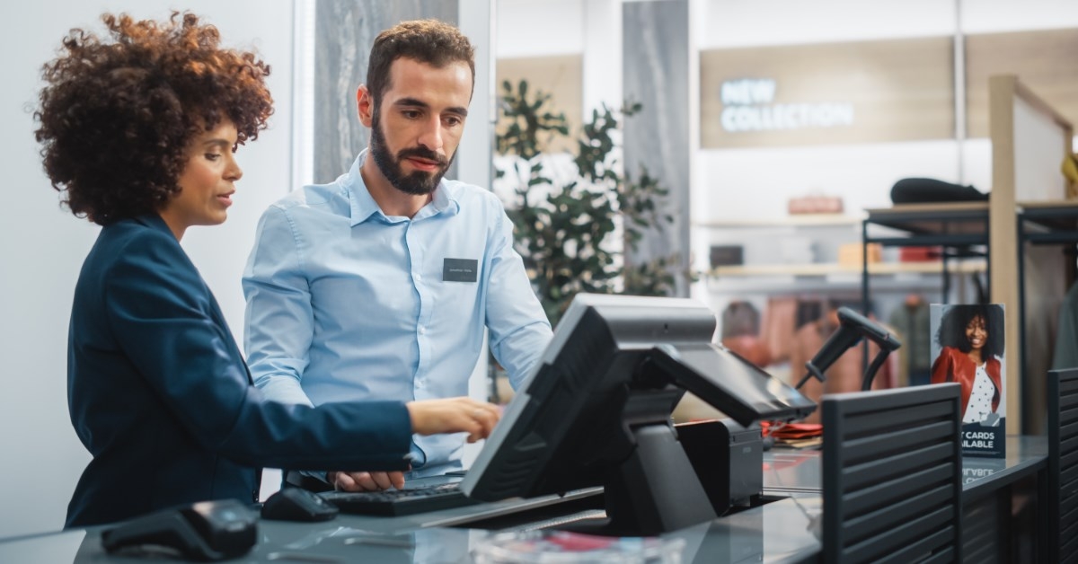 women explaining something to a cashier in a retail store
