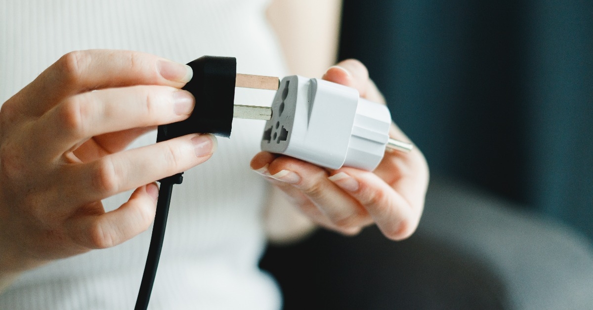 woman applies universal travel adapter 
