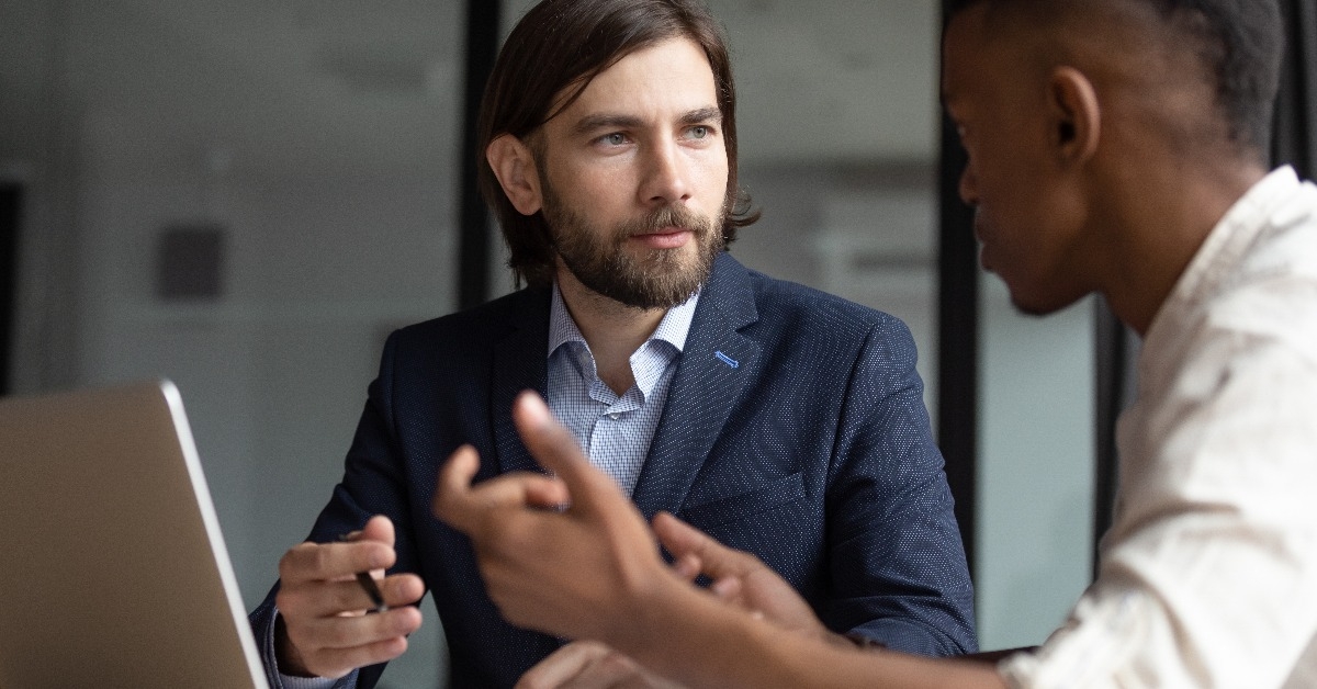 businessman listening to young male employee