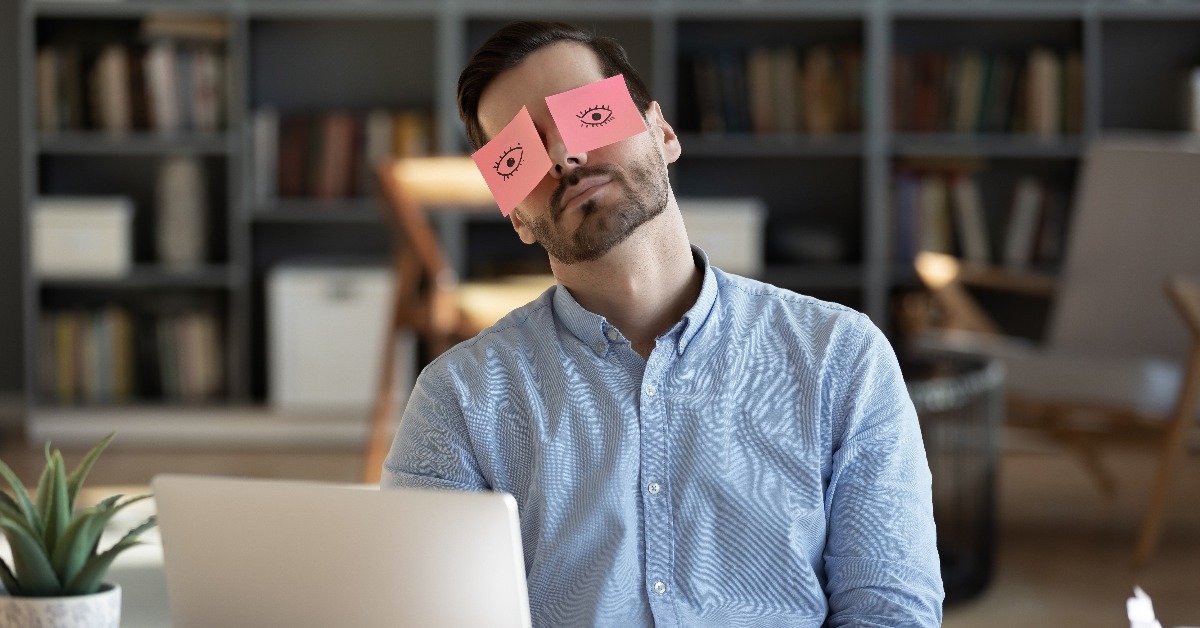 tired businessman with painted eyes on stickers
