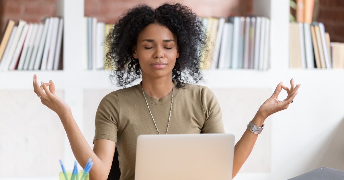 businesswoman meditating doing yoga at work