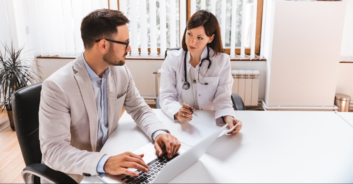 businessman talking with female doctor at the hospital