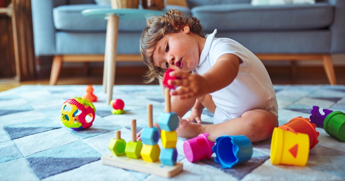 girl toddler playing with toys on the carpet
