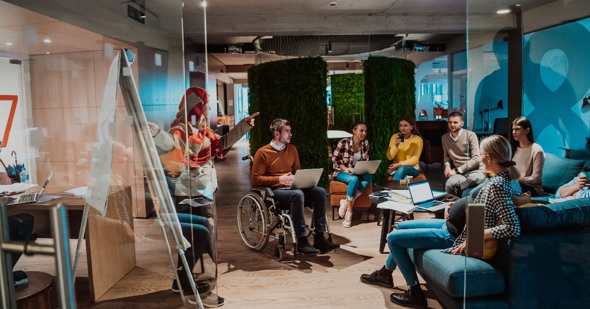 businesswoman presents a project to a young diverse team of people