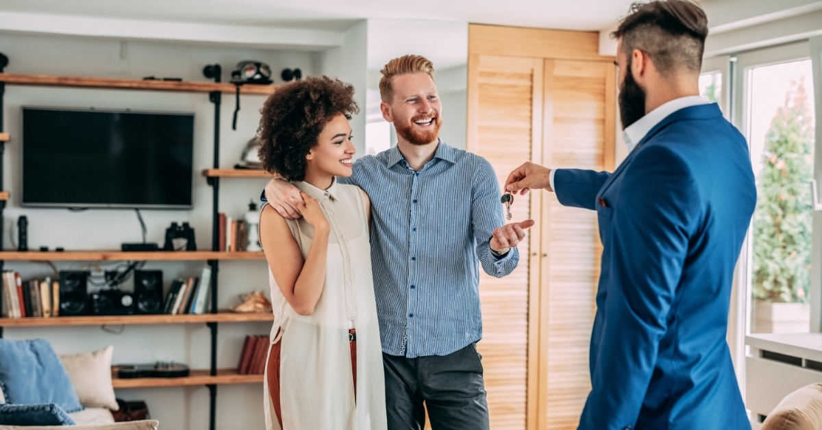 couple receiving keys from a real estate agent