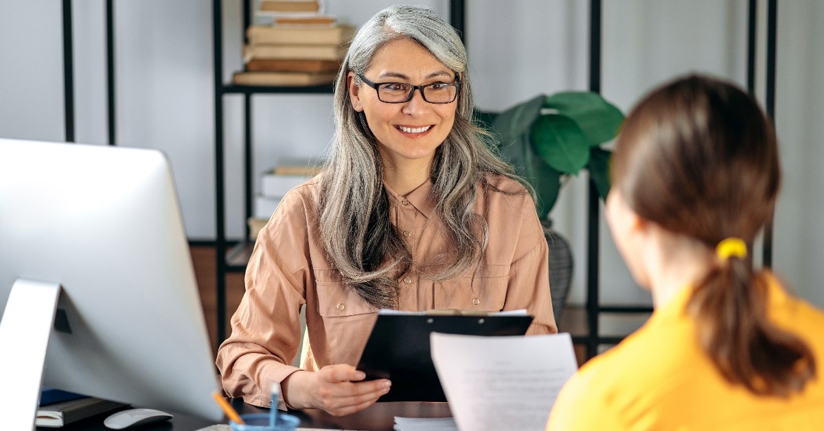 mature hr manager listening and looks at a  resume of a new applicant