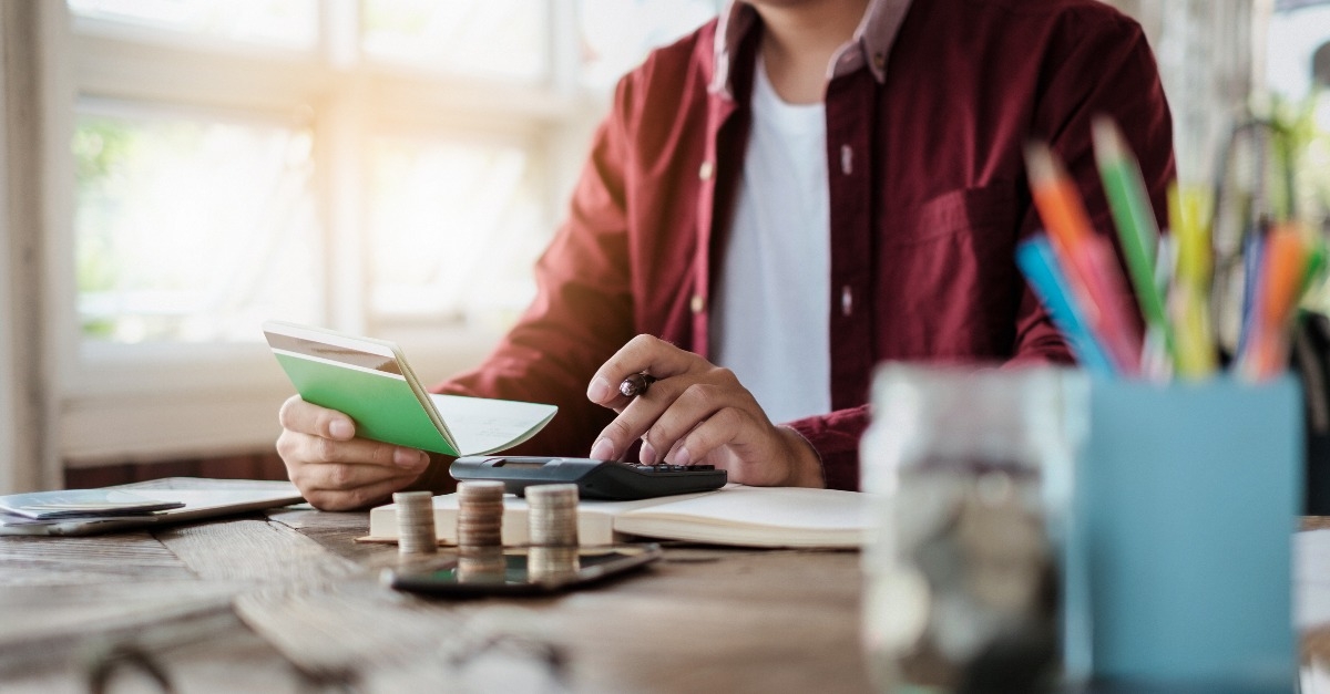 businessman holding saving account passbook with calculator