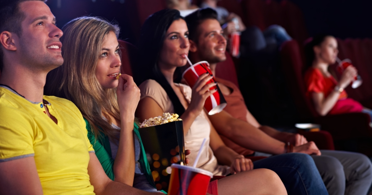 people in a movie theater with popcorns and cold drinks