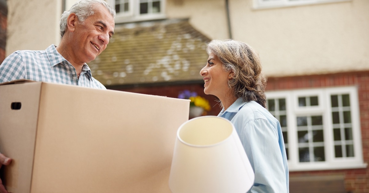 mature couple carrying boxes on moving day