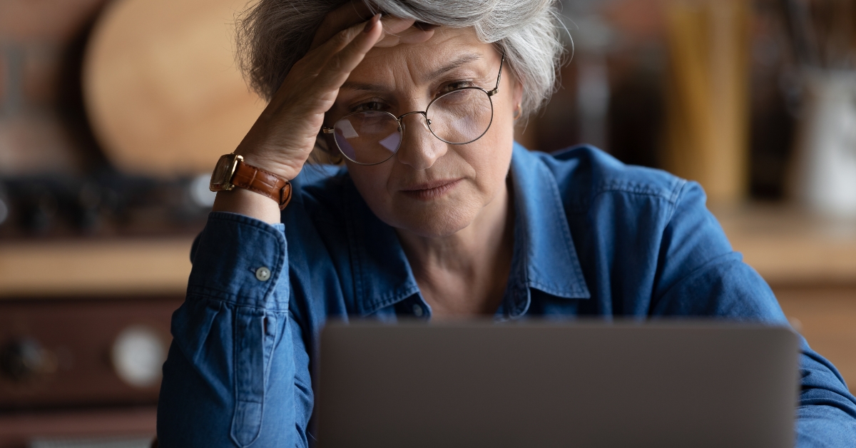 woman looks at laptop screen feels confused