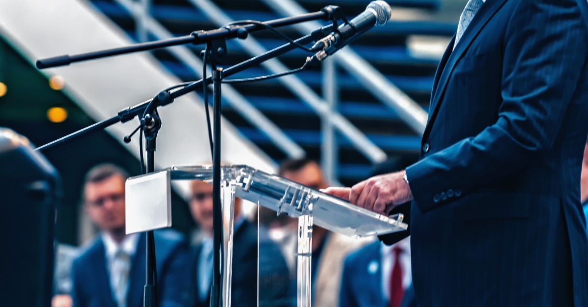 businessman in suit ready to read on stage