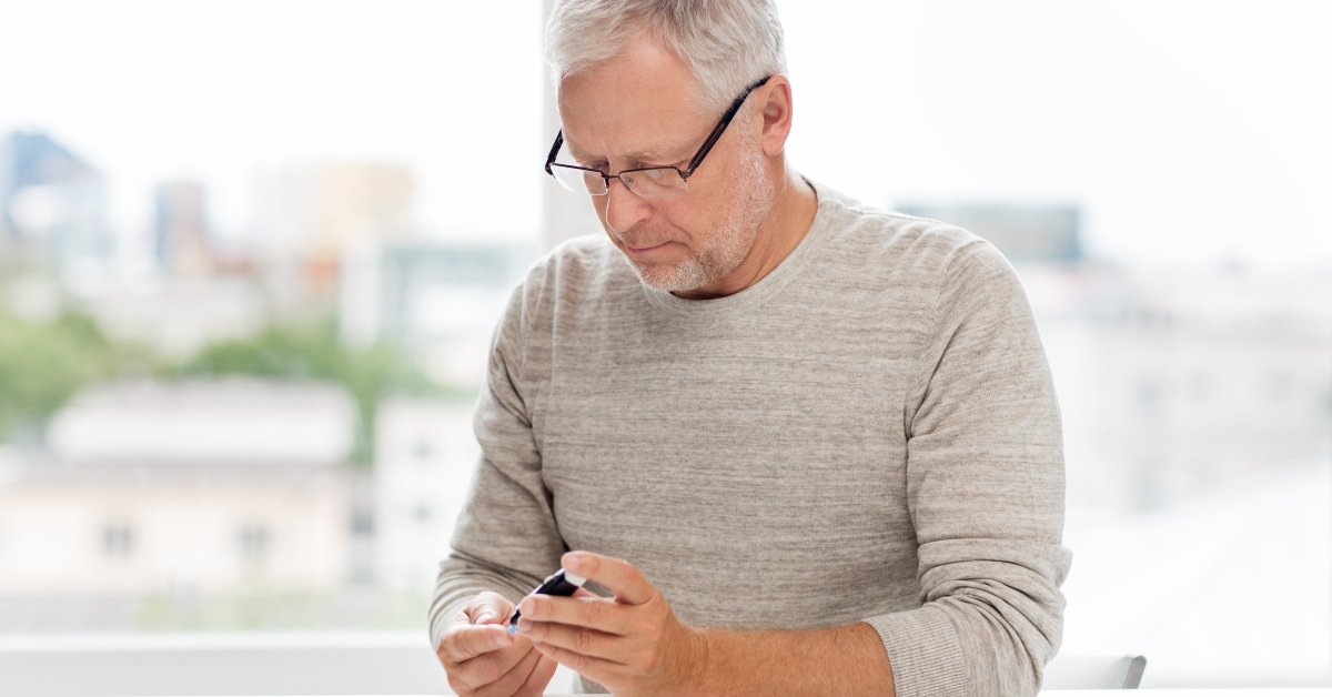 senior man with glucometer checking blood sugar