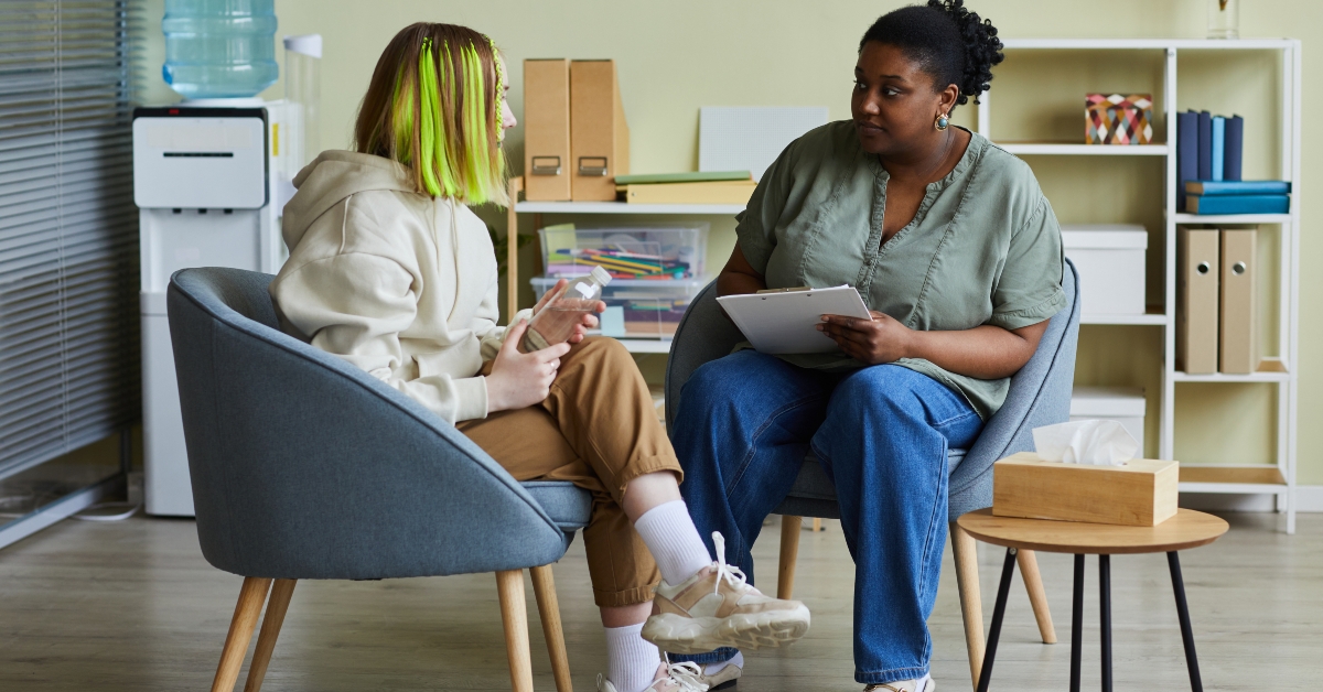 female social worker talking to difficult teenage girl