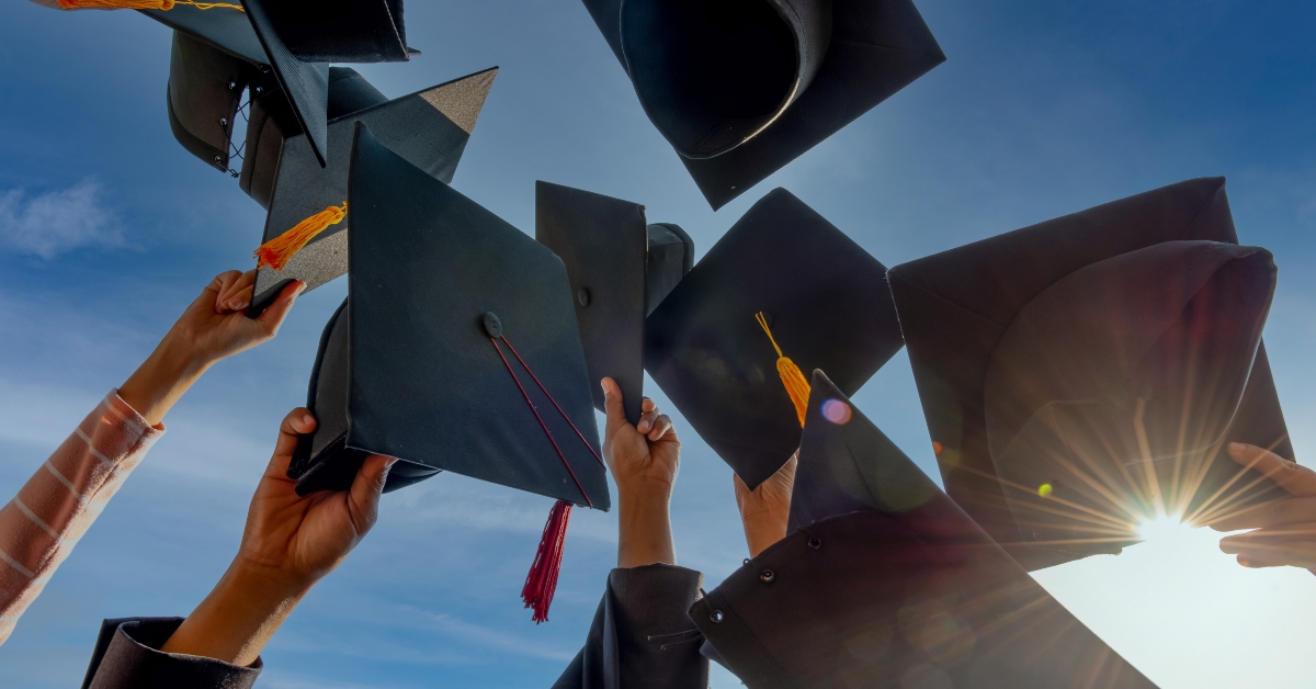 graduates throwing graduation hats up in the sky