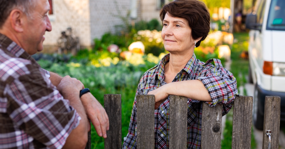 man and woman chatting near the fence